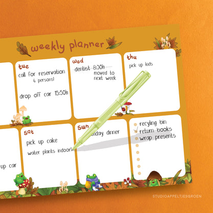 Monthly planner with mushrooms and frogs as decoration, filled in as an example.